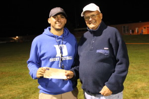 Drury High School Head Football Coach Seth Shepherd receives Williams Sideline Quarterback Club donation from Secretary, Bill Judge after their game against Mt. Greylock on Saturday, September 26, 2015.